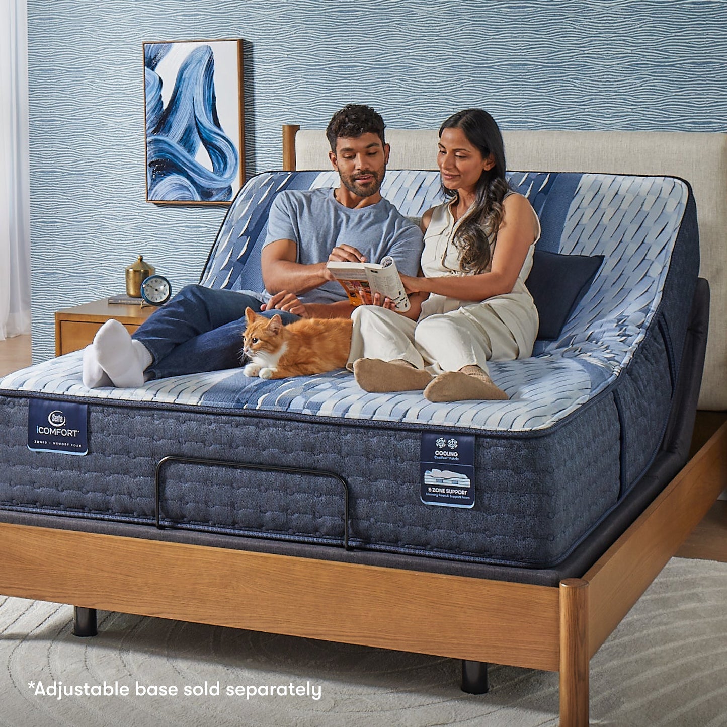 Woman and man sitting on a Serta iComfort mattress with a cat by their feet in between them reading a crossword puzzle || feel: plush || level: Standard - 12"