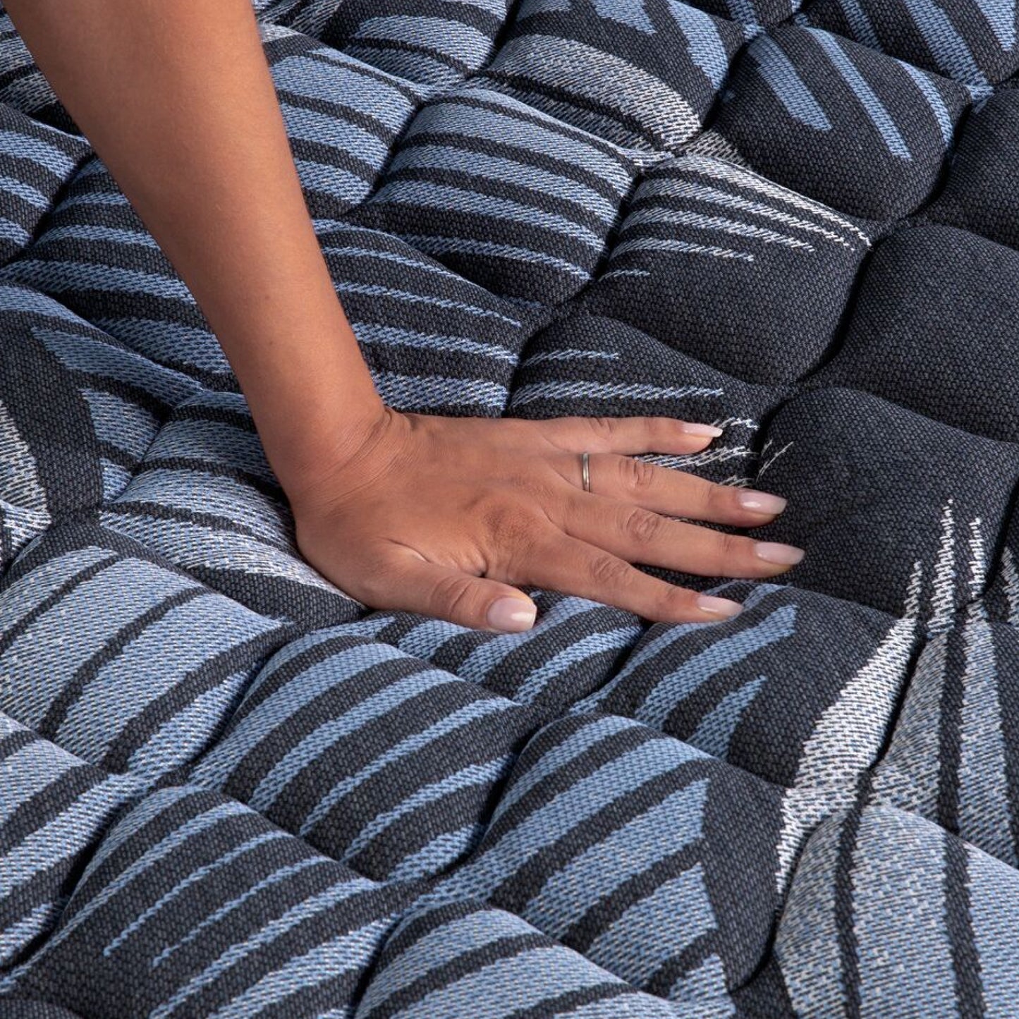 A hand pressing on the Serta Perfect Sleeper Sleep Excellence mattress showing it's firmness | feel: Firm