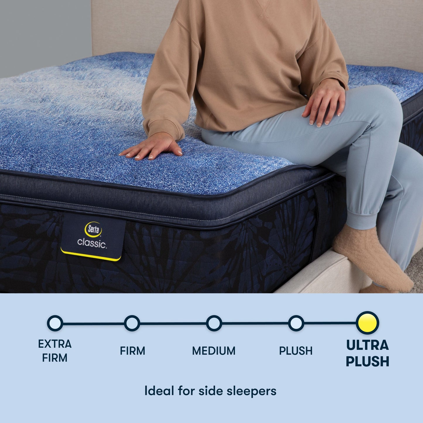 Woman sitting on a Serta classic plush pillow top mattress with her right hand placed on the mattress ||feel: plush pillow top ||level: enhanced