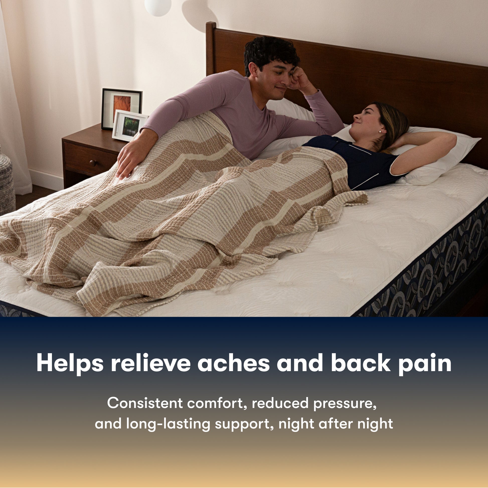 Couple lying in bed on a Serta perfect sleeper hybrid medium mattress under a striped blanket with text about back pain relief.