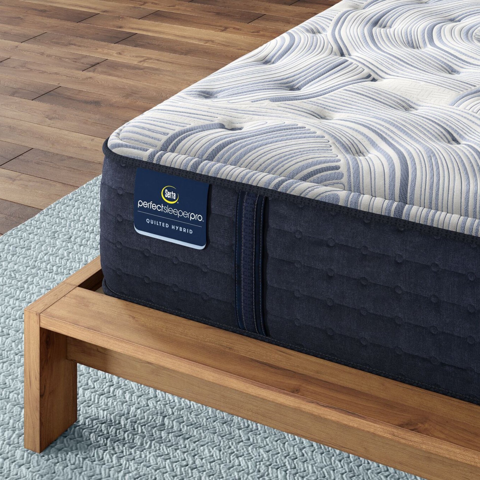 Corner of Perfect Sleeper Pro Kensington Medium mattress sitting in a brown bedframe || Level: Level 1 || Feel: Medium