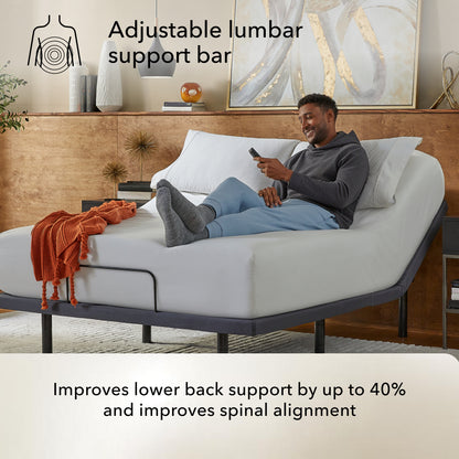 Man using a smartphone on a bed on a Baselogic Pearl adjustable base lumbar support bar highlighted.
