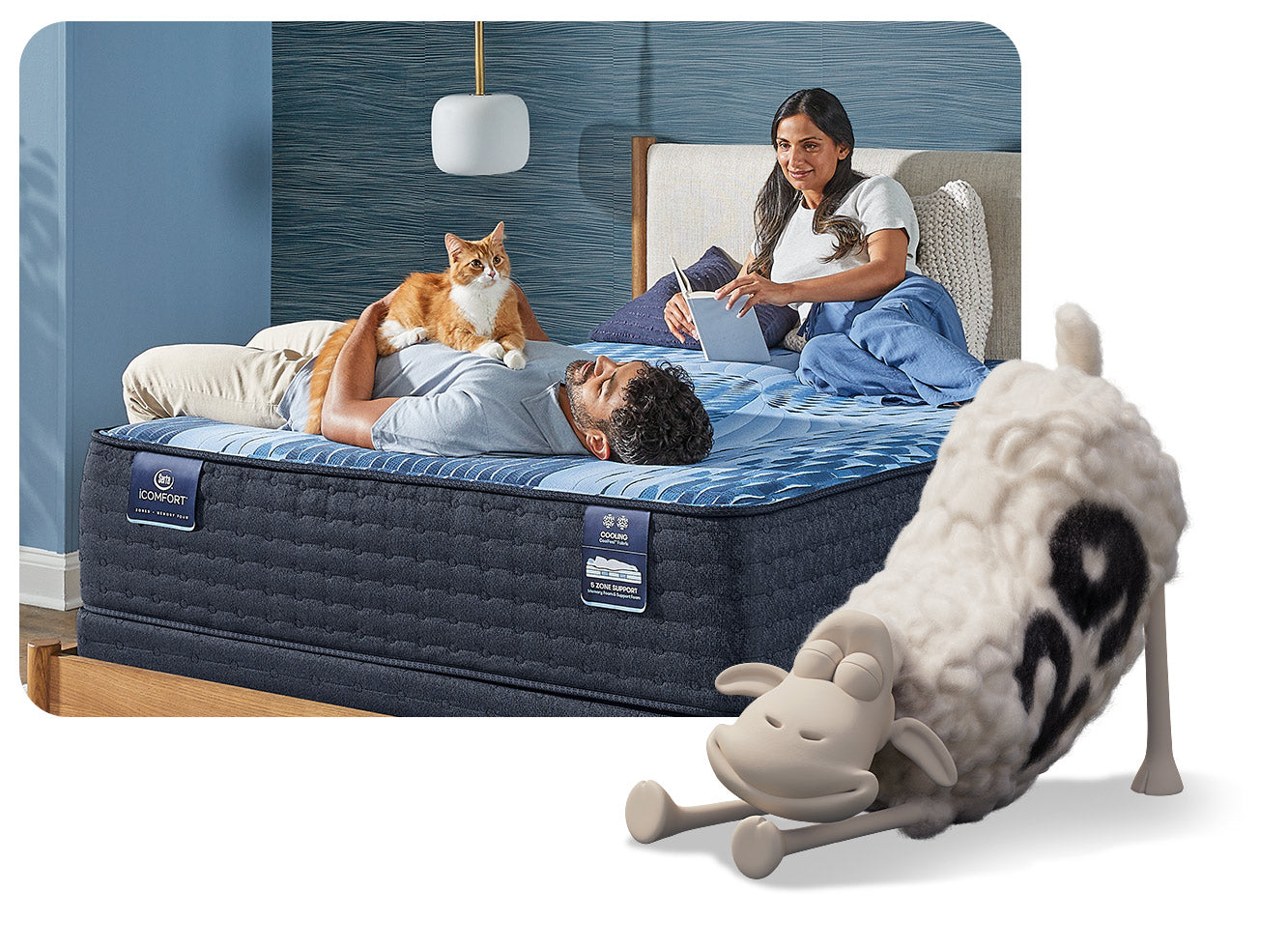 A man and his wife lay on a blue and white Serta iComfort mattress in their modern bedroom. The man is cuddling his orange cat while his wife reads a book.