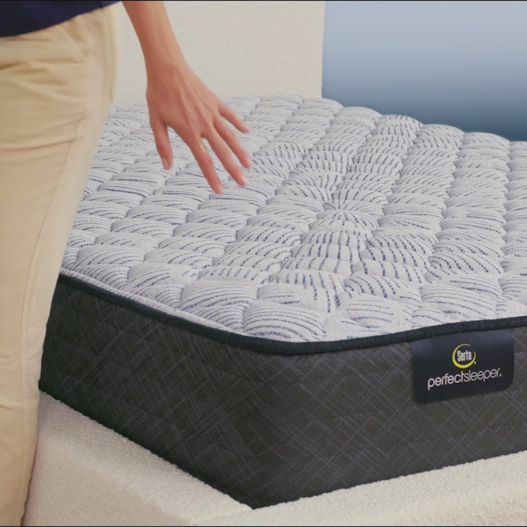 Person sitting on bed to show firmness level of Serta Perfect Sleeper firm mattress||feel: firm||level: enhanced
